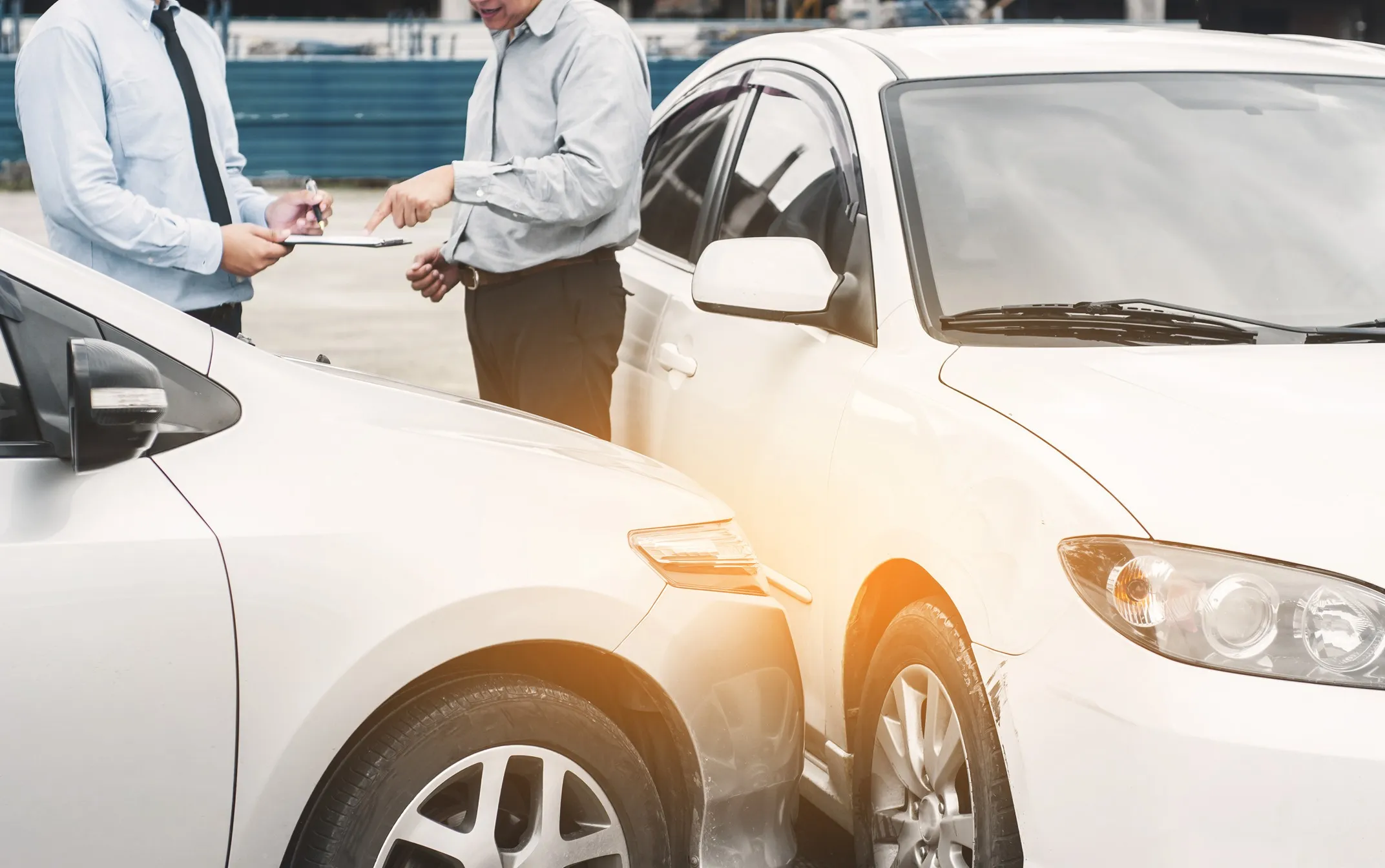 Two men discuss damage after a car accident in El Paso.